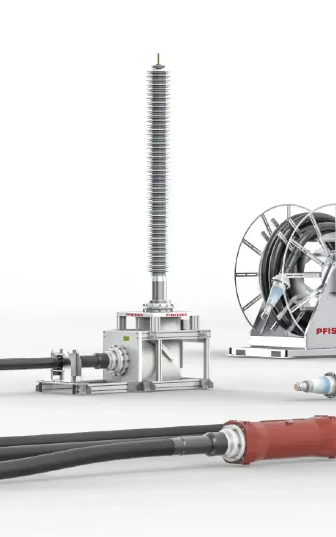 Elektrische Hochspannungsausrüstung mit Kabeln und Steckern; ein hoher Isolator steht aufrecht neben einer Kabeltrommel und zusätzlichen Stromkabeln vor einem weißen Hintergrund.